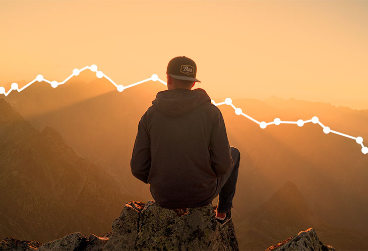Person sitting on a mountain and contemplating their website's growth by viewing Google Analytics