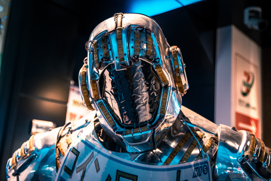 Photo of a silver robot's head with blue and warm white light reflecting off it