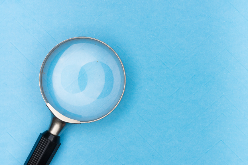 A magnifying glass against a light blue background.